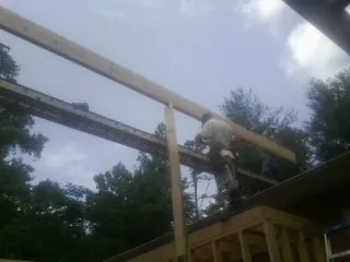 Carpenter setting a ridge beam over a new addition frame — Ice Dam Removal by Roofing Brothers in Sturbridge