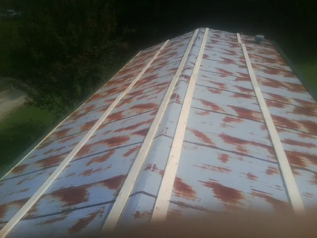 Rusted metal roof panels with new wood purlins before replacement — Storm Damage Roof Repair in Sturbridge by Roofing Brothers