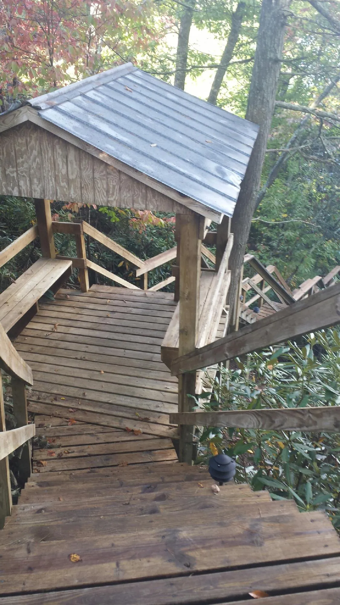 Metal roofed shelter over wooden steps on a wooded walkway — Skylight Repair & Installation work by our crew in Sturbridge