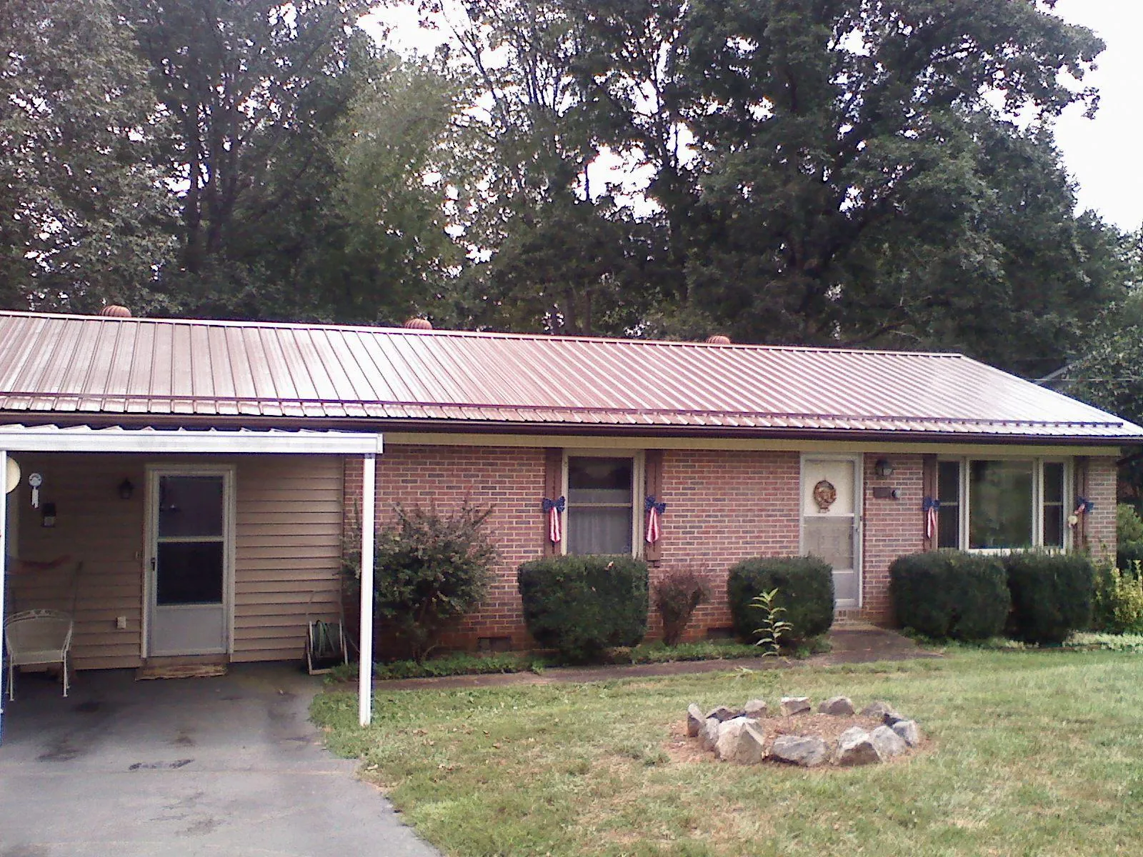 Bronze metal roof and carport on a brick ranch home — Roof Repair work by our crew in Sturbridge